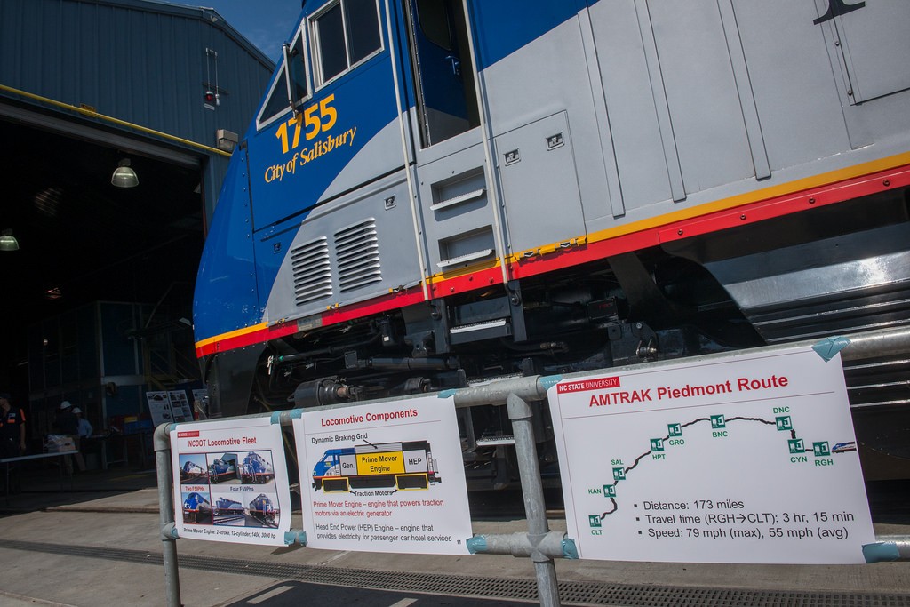 Posters describing NCDOT’s locomotive fleet and the Amtrak-operated Piedmont rail service, with locomotive NC 1755 in the background.